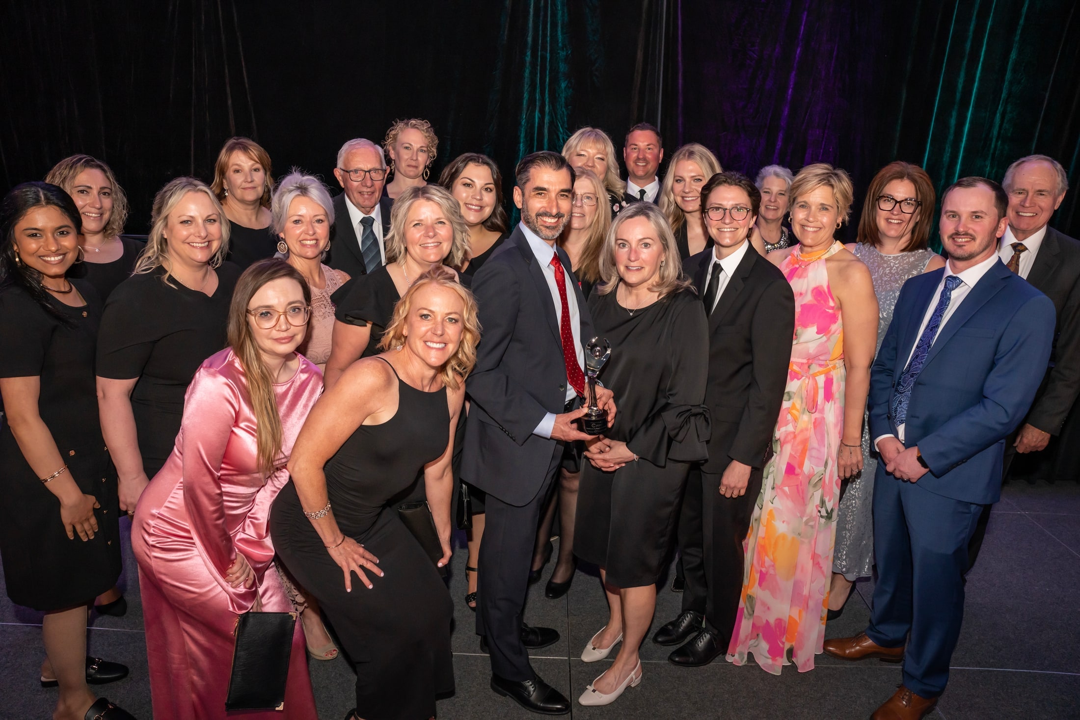 Group photograph of an award-winning team at an evening event